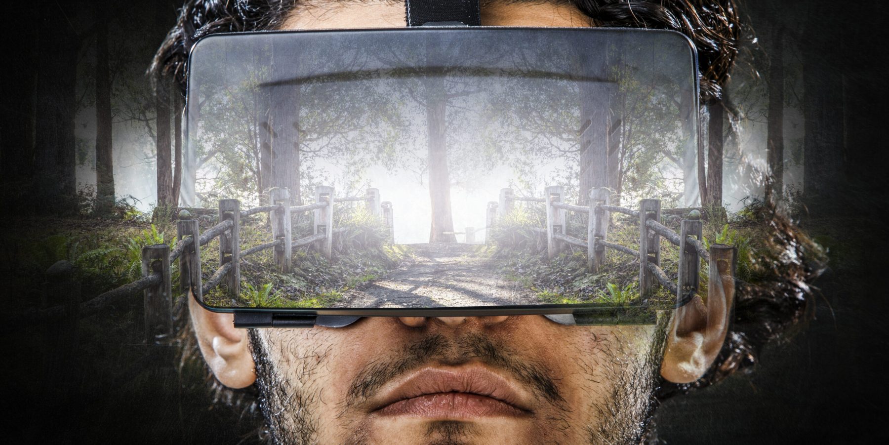 Portrait of a young man in VR helmet on forest nature background.
